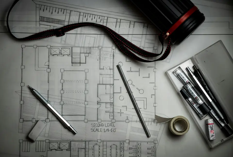Architectural blueprints with pencils and a metal ruler